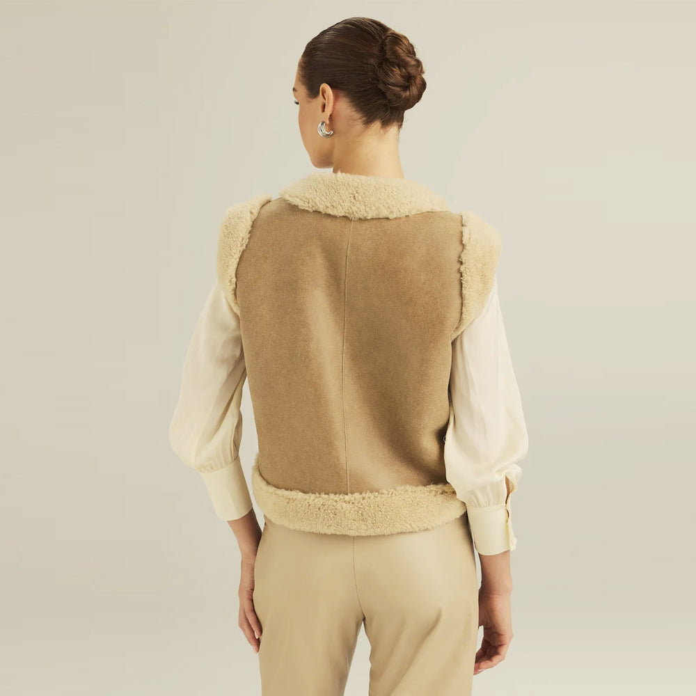 Back view of women’s cropped tan suede shearling vest with center seam and ivory wool edging