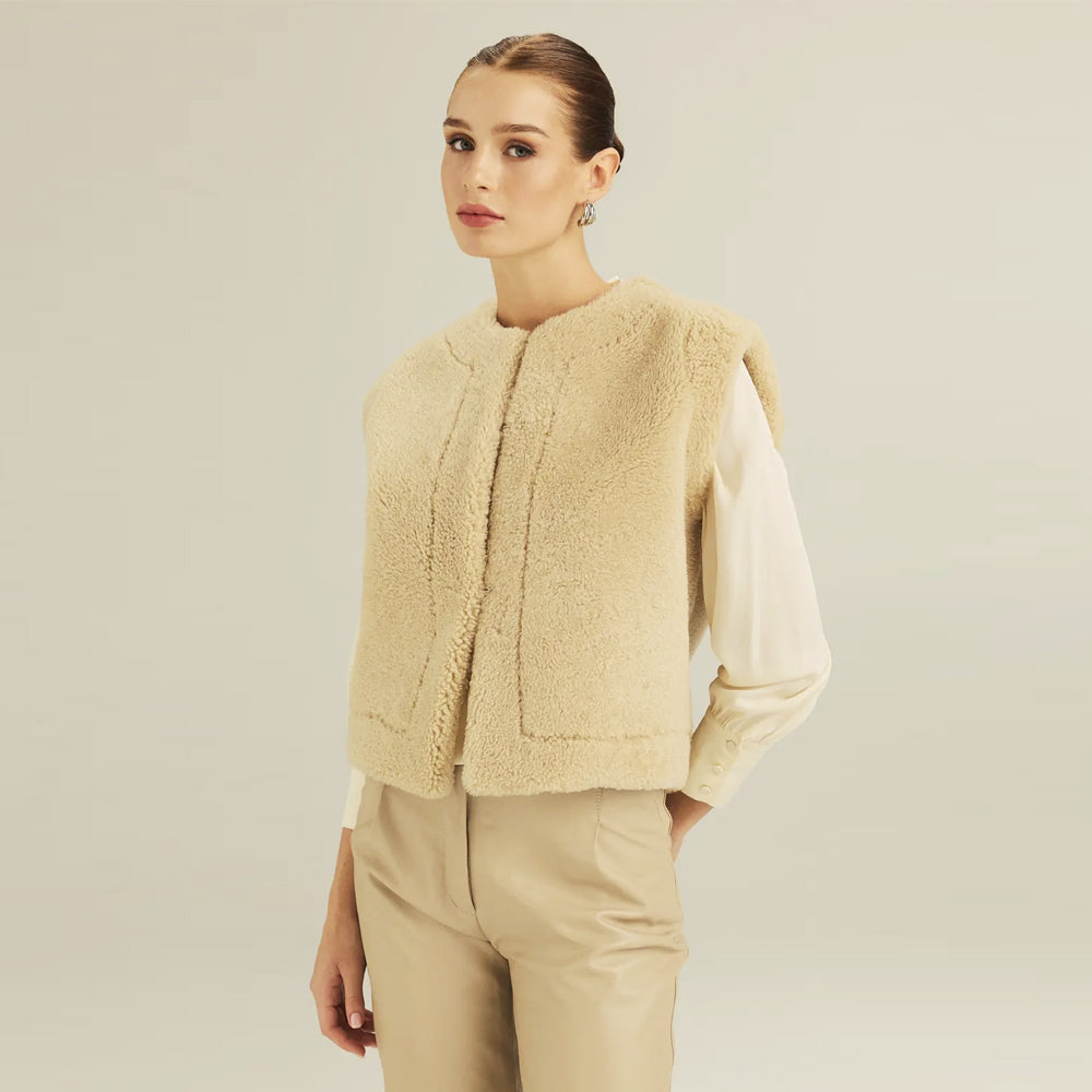 Women’s reversible shearling vest worn with the ivory fleece side facing outward
