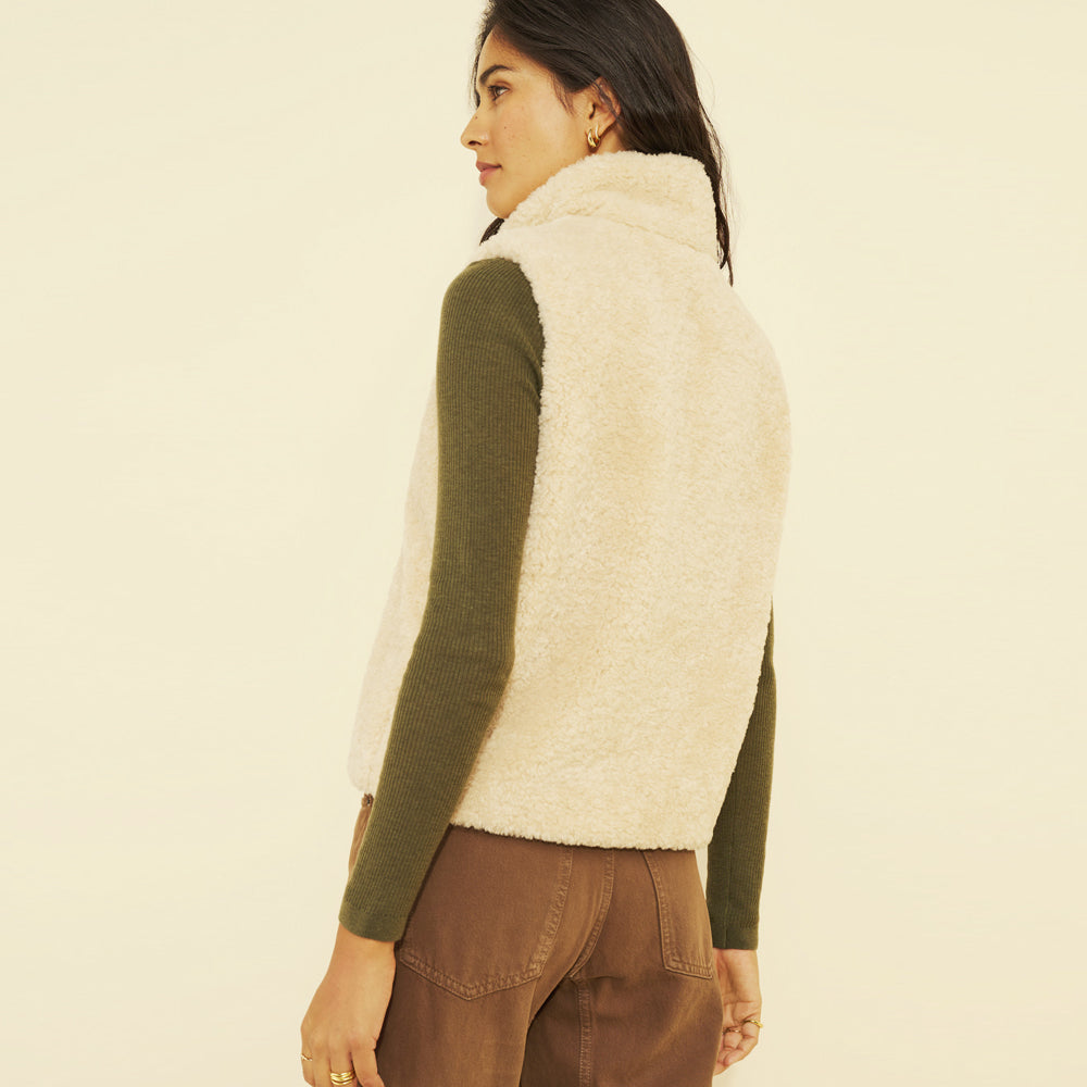 Back view of a women’s ivory teddy vest with a raised collar and relaxed sleeveless shape.