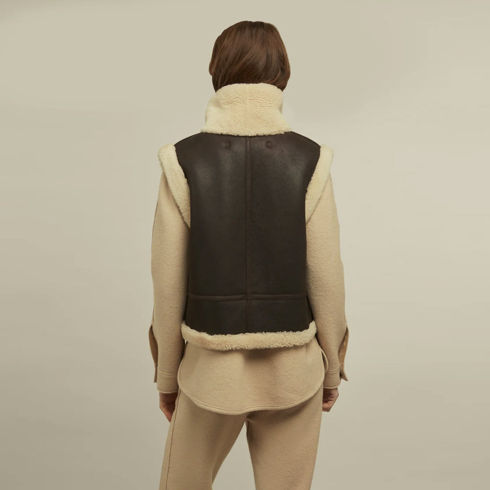 Rear view of women’s brown lambskin shearling vest with center seam and ivory-trimmed armholes