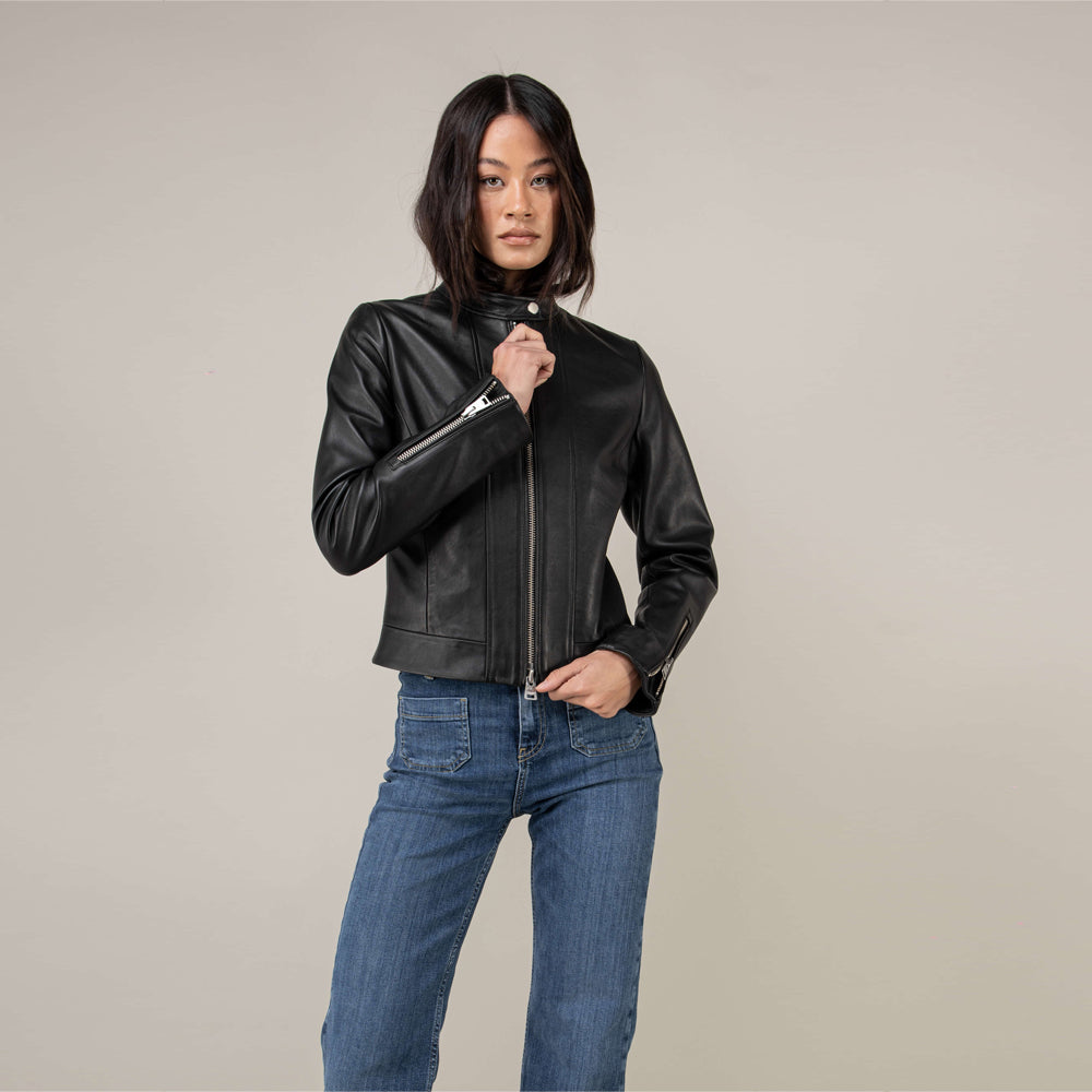 Front view of women’s oil-black lambskin moto jacket styled with blue jeans
