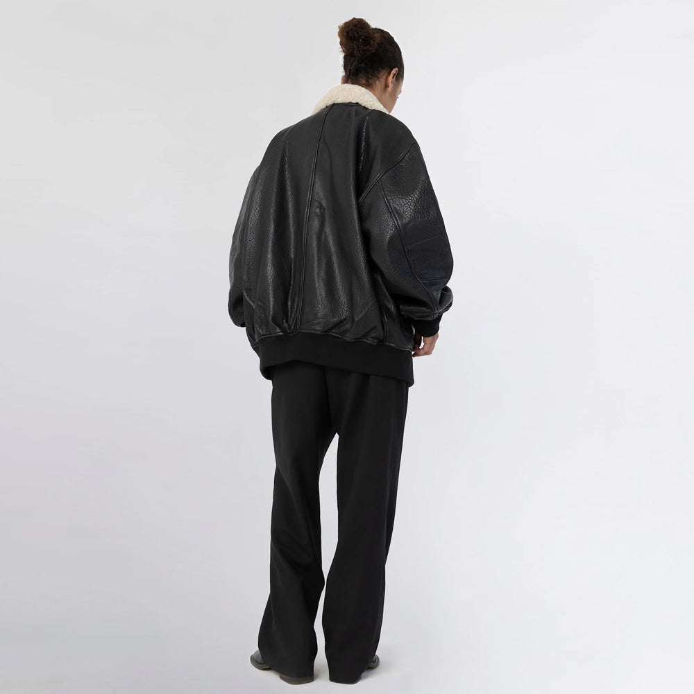 Full back view of women’s oversized black leather bomber jacket