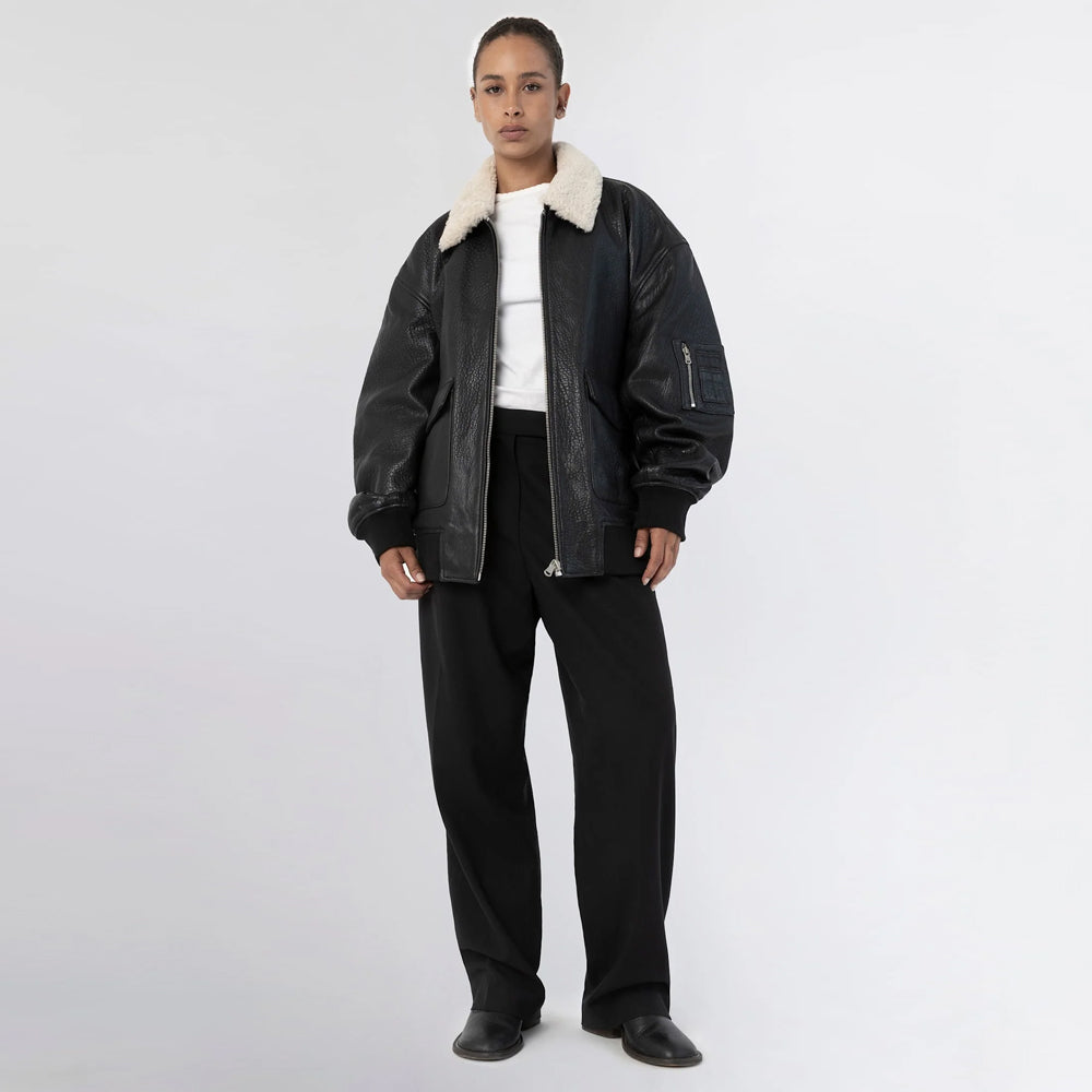 Full-length front view of oversized black leather bomber jacket worn open