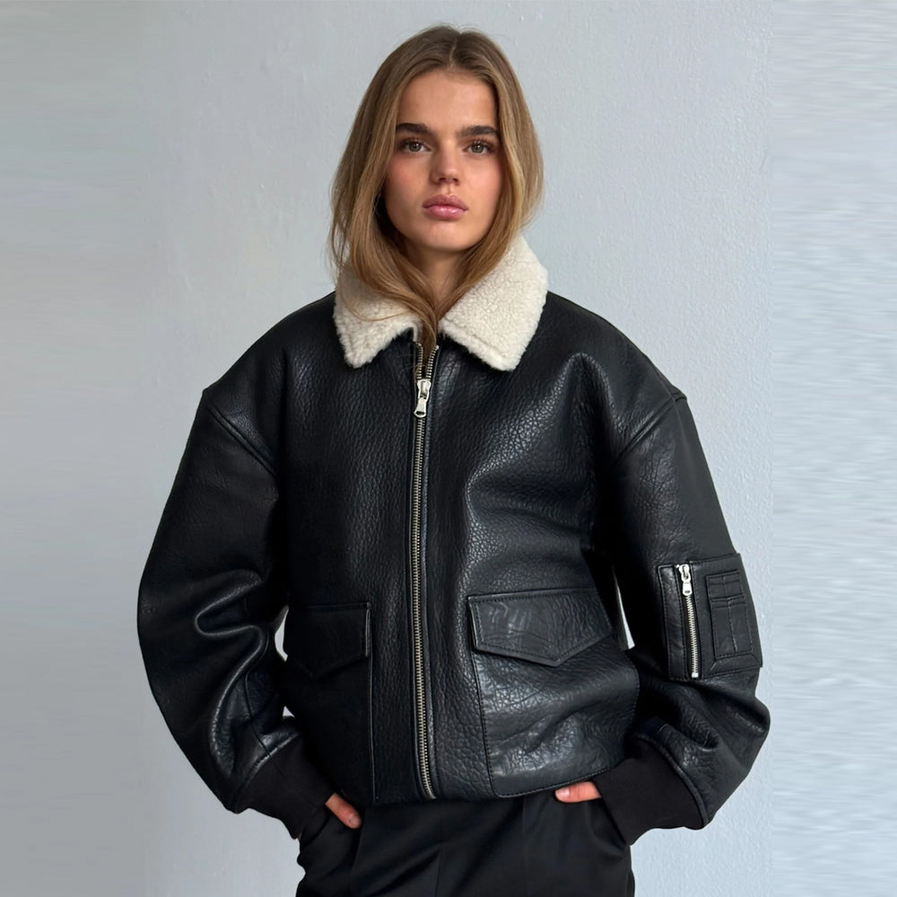 Woman wearing an oversized black cow leather bomber jacket with a cream shearling collar