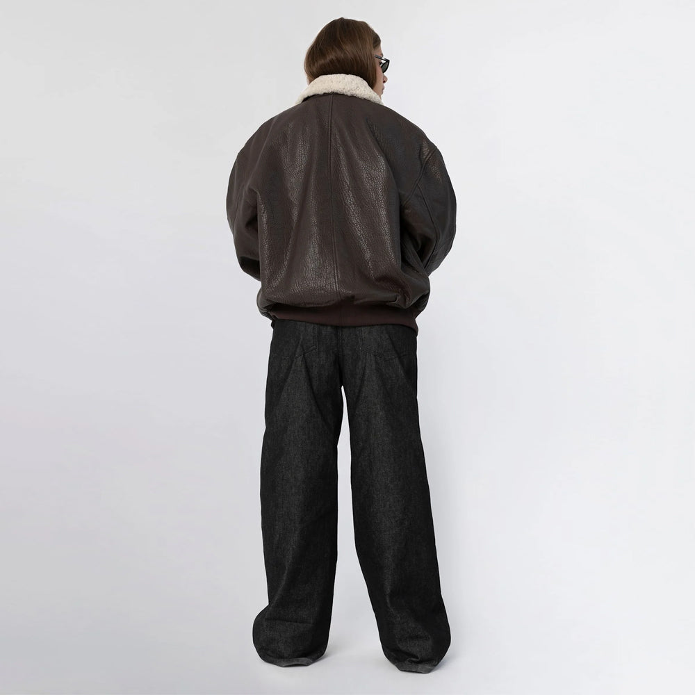 Full back view of women's oversized brown leather bomber jacket with ribbed hem and shearling collar