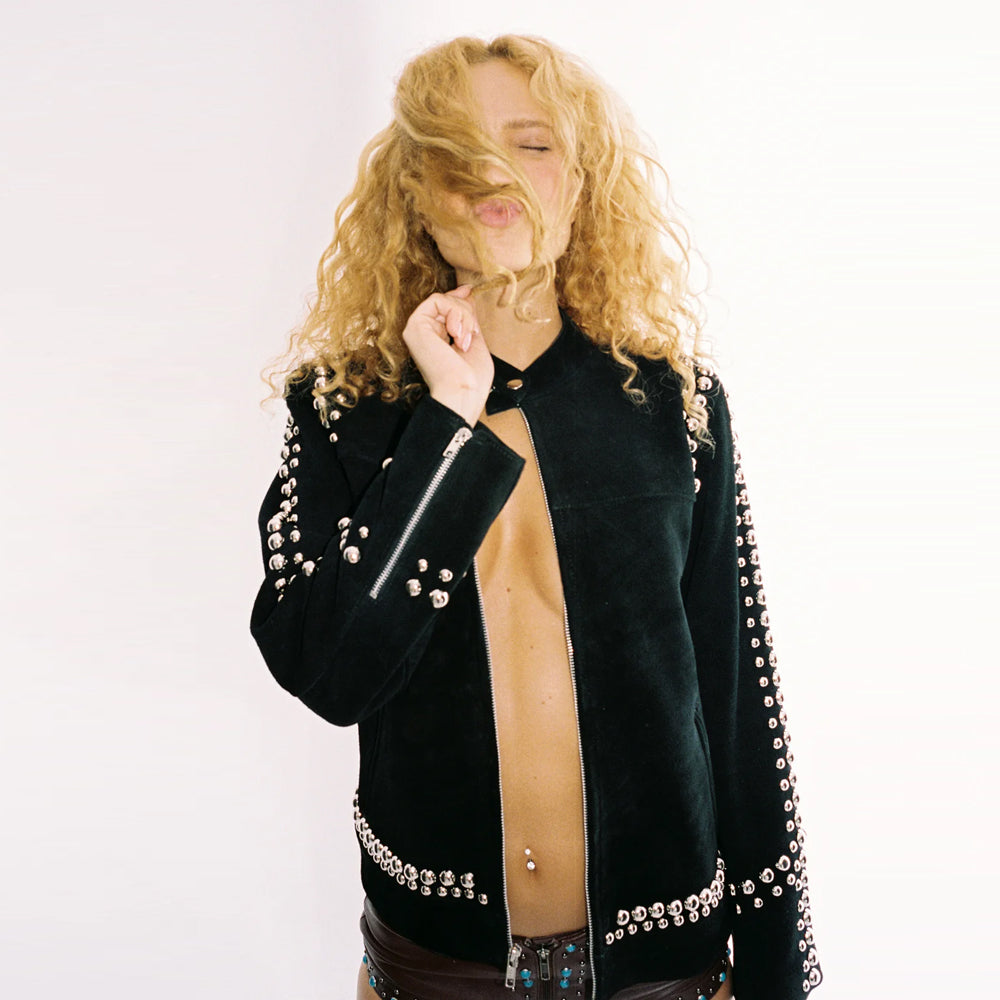 Model wearing the black studded jacket with the neck snap-button fastened while keeping the front zipper open.