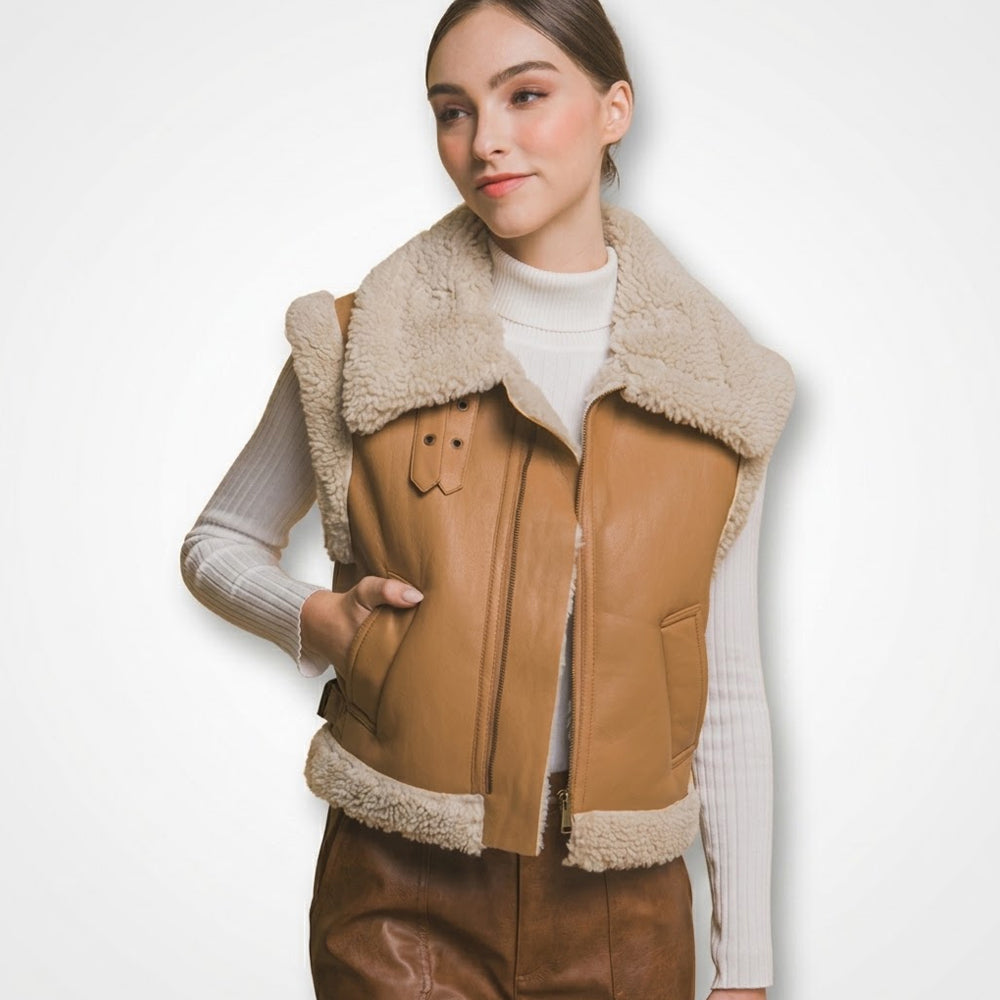 Woman wearing a tan lambskin shearling aviator vest with an oversized cream collar