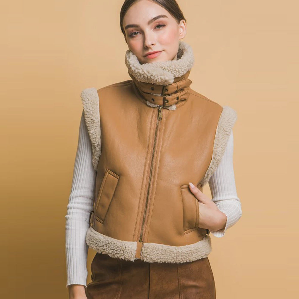 Women’s tan shearling aviator vest with twin-buckle high collar secured around the neck