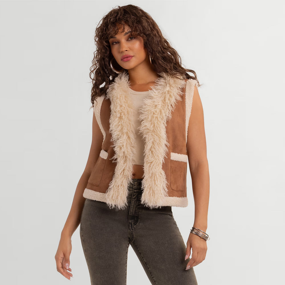Woman wearing a tan goatskin suede fur-lined vest with shaggy cream open front and patch pockets