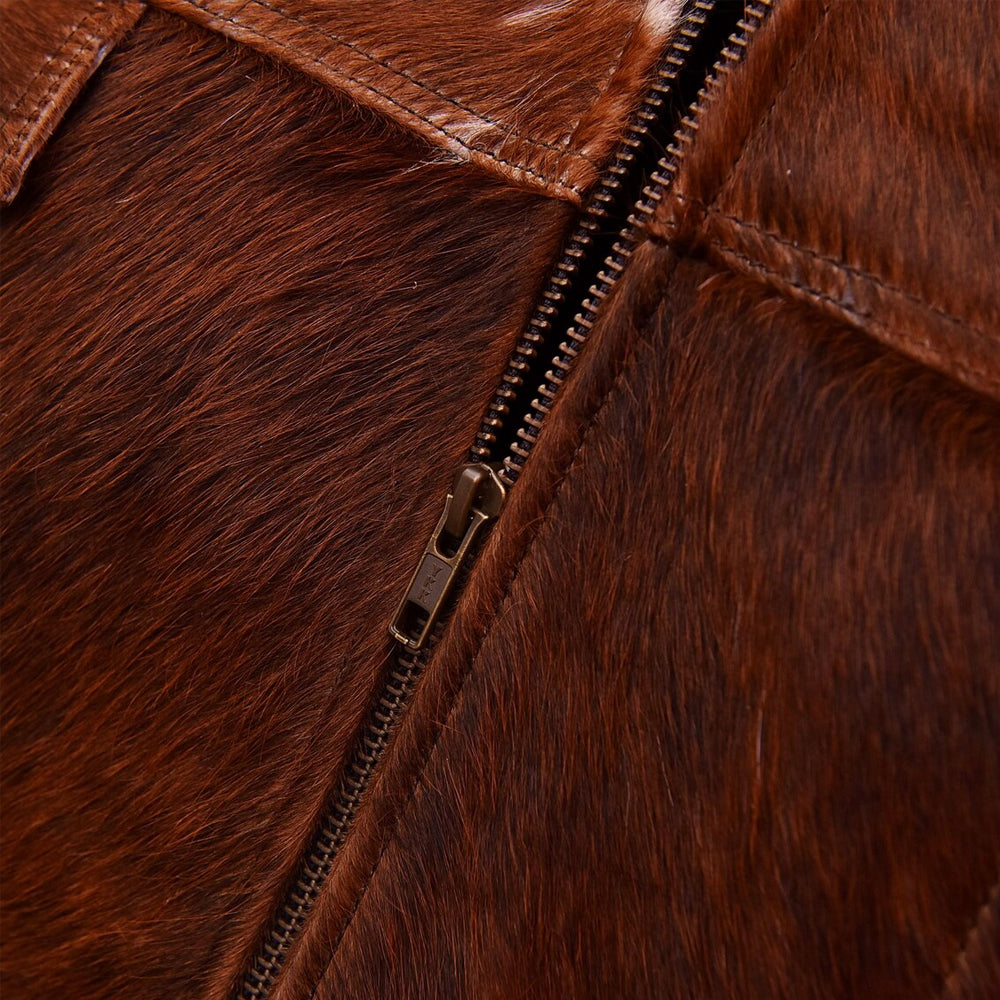Close-up of the YKK antique-brass zipper and topstitched chestnut hair-on cowhide panels