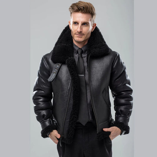 Male model wearing open black sheepskin flight jacket over black dress shirt and tie in studio setup