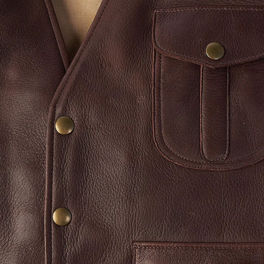 Detailed close-up of the premium brown buckskin leather grain texture featuring burnished brass snap buttons and heavy duty stitching.