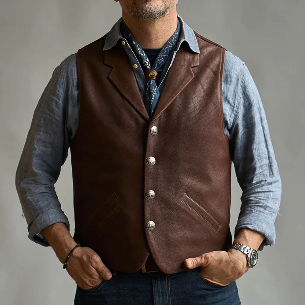Front profile of a man wearing the buttoned tobacco brown leather cowboy waistcoat with hands in pockets.