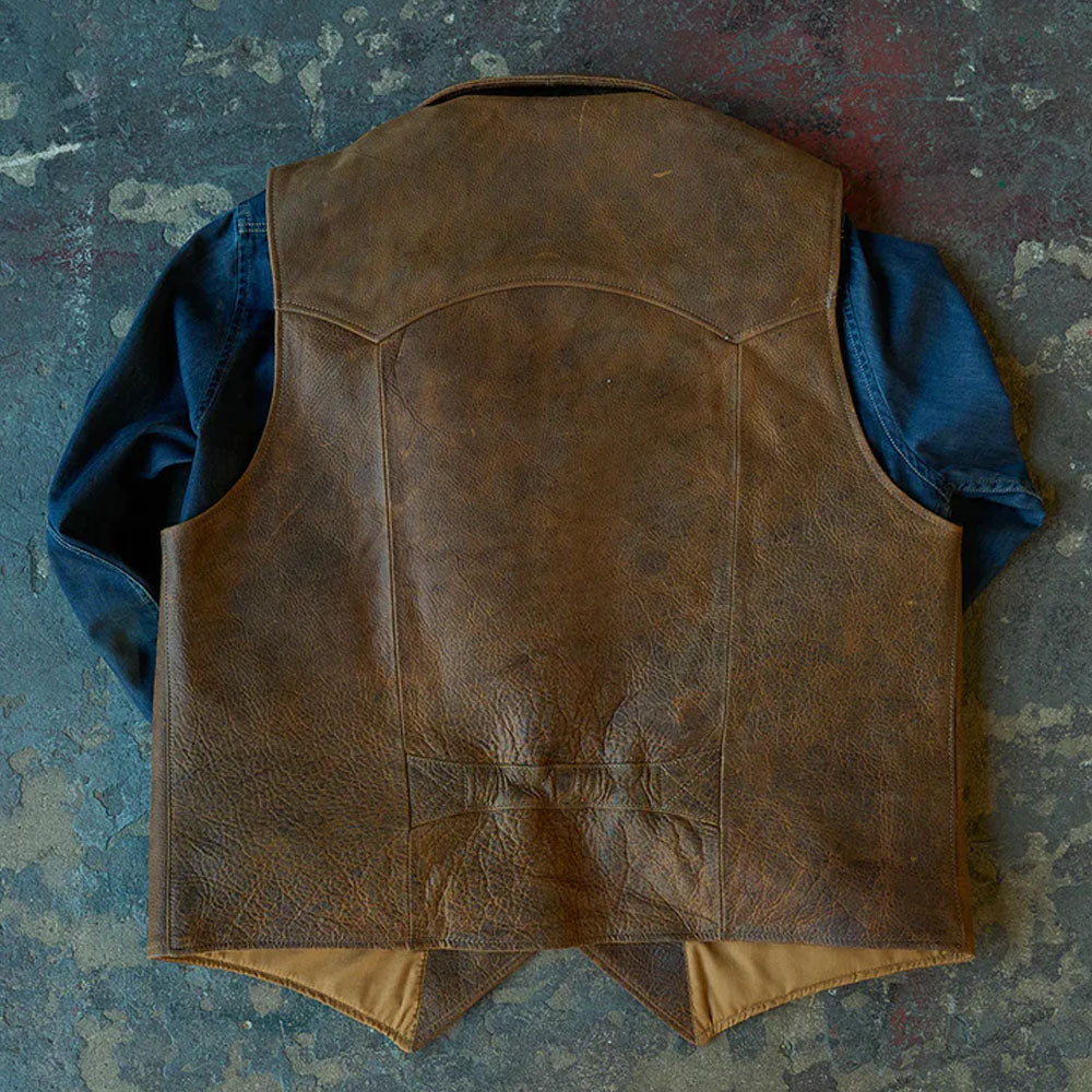 Rear profile of the brown leather cowboy waistcoat worn over a blue shirt, showing the clean stitching.
