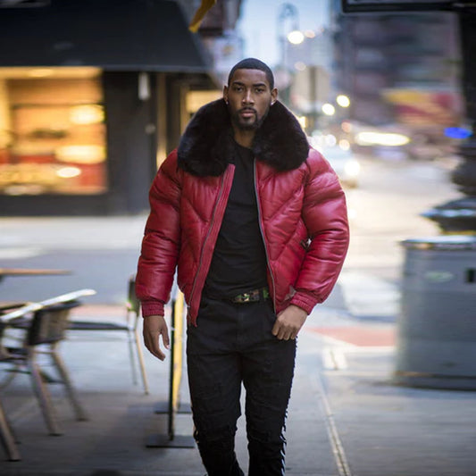 Front view of a model walking down the city street wearing the men's red lambskin leather V-bomber jacket styled open.